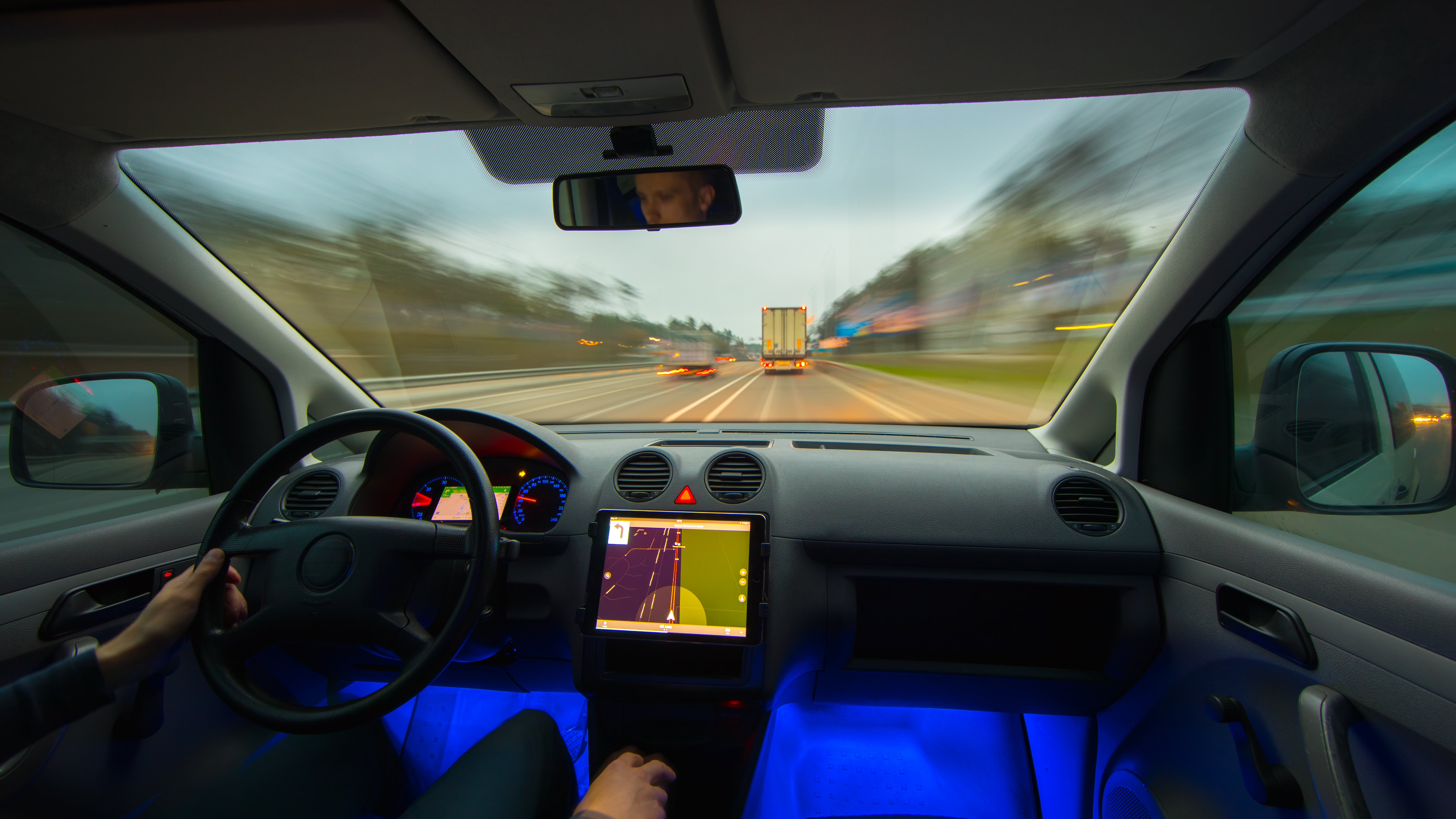 The man drive a vehicle on the highway. Inside view. Wide angle